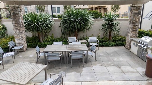 view of patio with outdoor dining space, area for grilling, and a grill