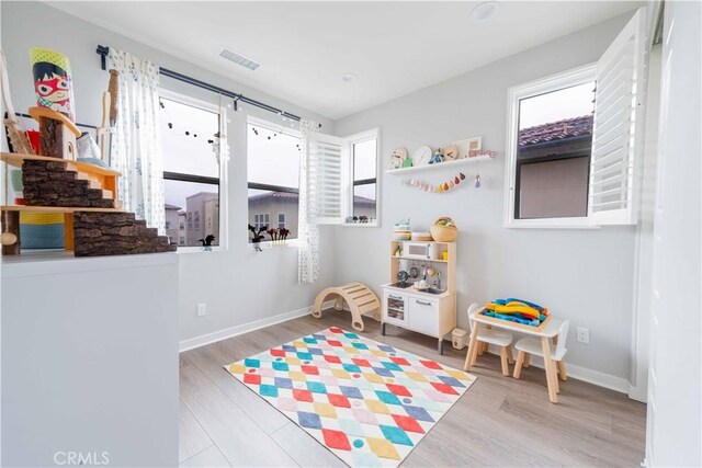 game room with visible vents, baseboards, and wood finished floors