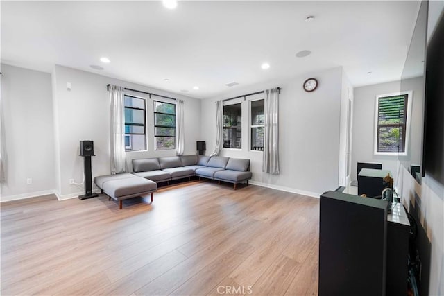 living room featuring recessed lighting, light wood-style floors, and a healthy amount of sunlight