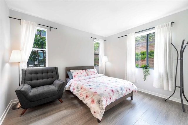 bedroom with baseboards and wood finished floors