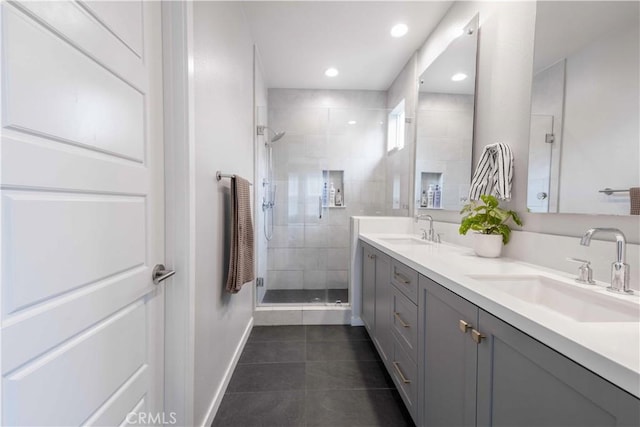 full bathroom with tile patterned flooring, a shower stall, double vanity, and a sink