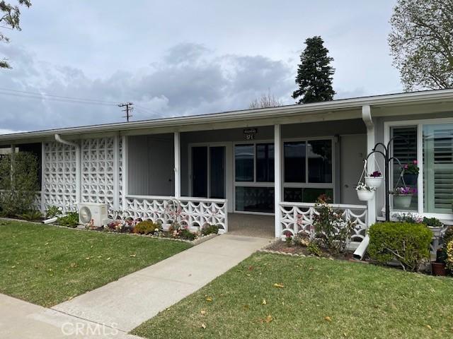 view of exterior entry featuring ac unit, a yard, and a porch