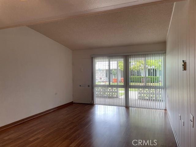 spare room featuring a textured ceiling, baseboards, and wood finished floors