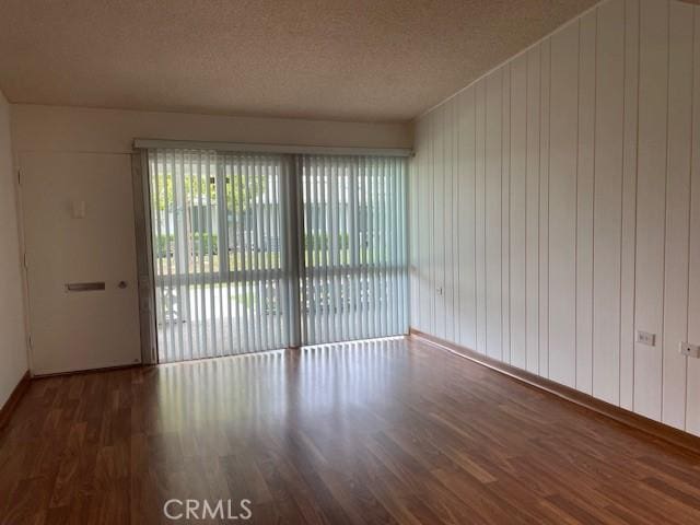 spare room featuring wood finished floors and a textured ceiling