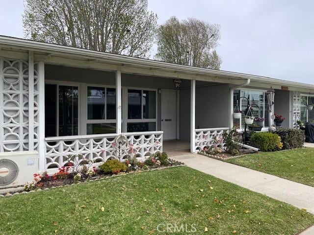 view of front of home with a front lawn, ac unit, and covered porch