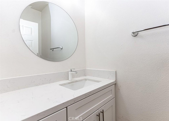 bathroom featuring vanity and a textured wall