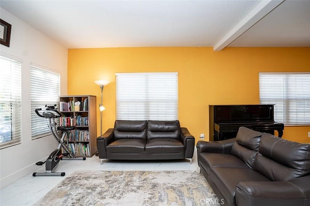 living area featuring baseboards and beam ceiling