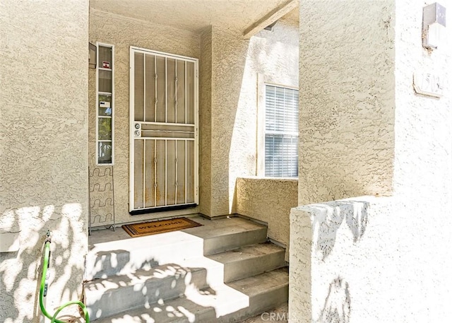 view of exterior entry with stucco siding