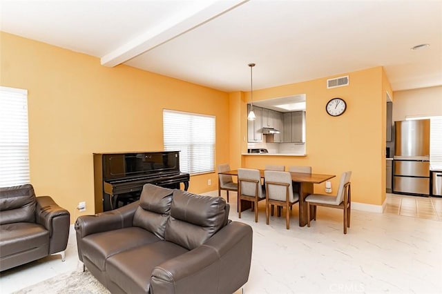 living area with beam ceiling, baseboards, and visible vents