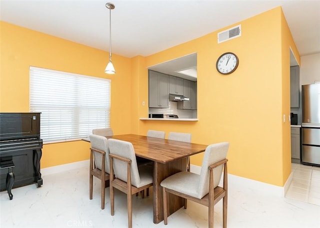 dining area featuring visible vents, baseboards, and marble finish floor