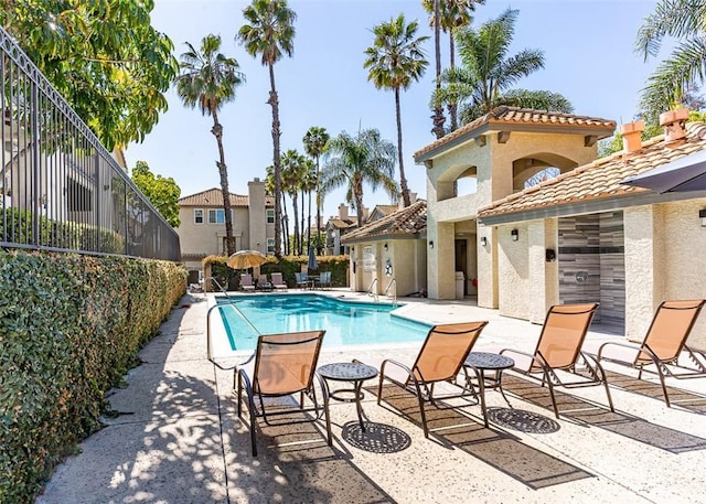 pool with a patio area and fence