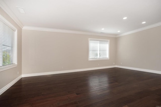 empty room with dark wood finished floors, recessed lighting, crown molding, and baseboards