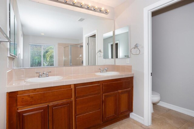 full bathroom featuring a sink, toilet, a shower stall, and tile patterned floors