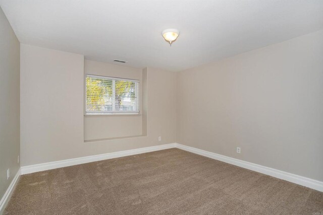 carpeted empty room featuring visible vents and baseboards