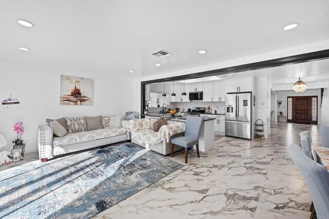 living room with recessed lighting, visible vents, marble finish floor, and a chandelier