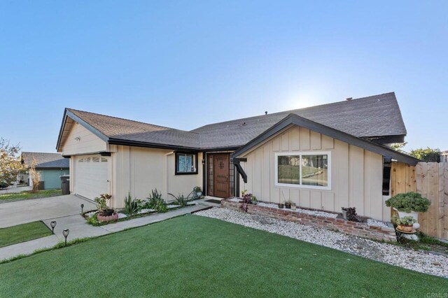 view of front of property featuring board and batten siding, a front lawn, fence, concrete driveway, and an attached garage