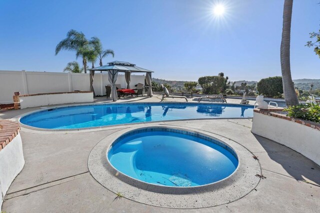 view of pool featuring an in ground hot tub, a fenced in pool, fence, and a patio