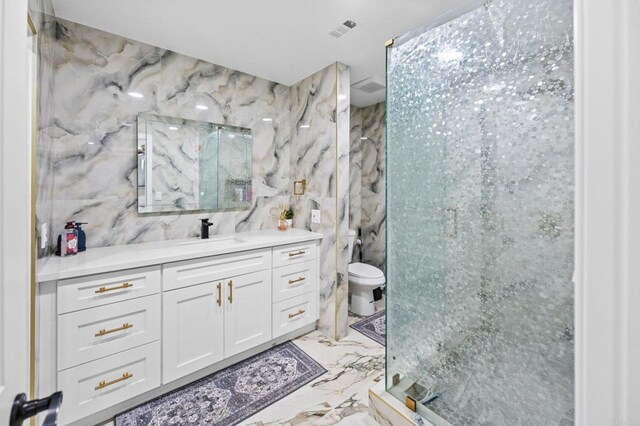 full bath featuring visible vents, marble finish floor, a marble finish shower, tile walls, and vanity