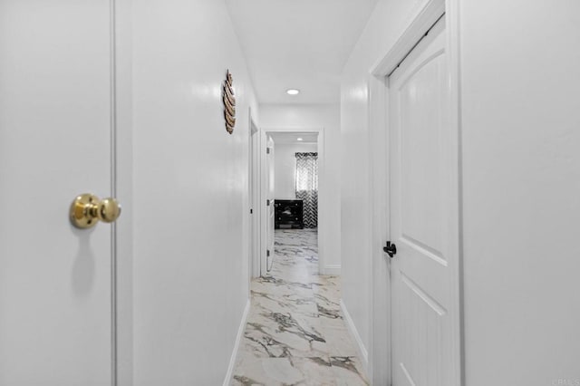 corridor with marble finish floor and baseboards