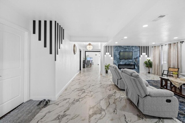 living area with recessed lighting, visible vents, baseboards, and marble finish floor