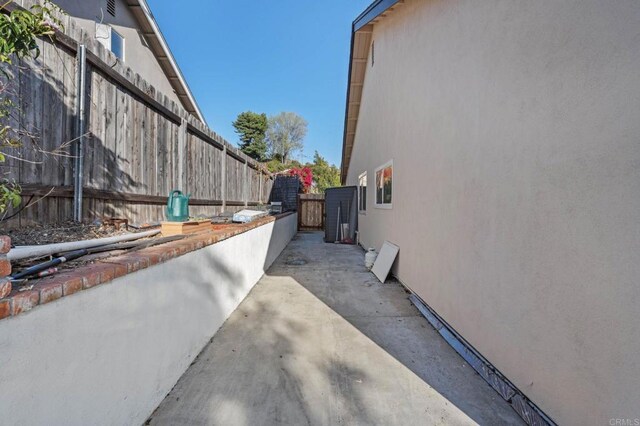 view of property exterior featuring a patio area, stucco siding, and fence