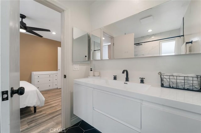 bathroom featuring wood finished floors, recessed lighting, walk in shower, ceiling fan, and vanity