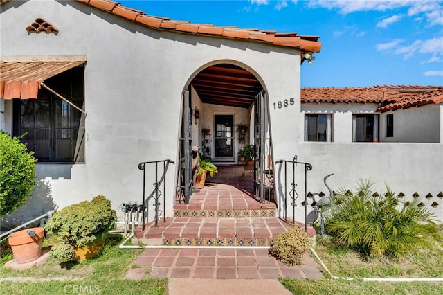 property entrance featuring stucco siding and a tiled roof