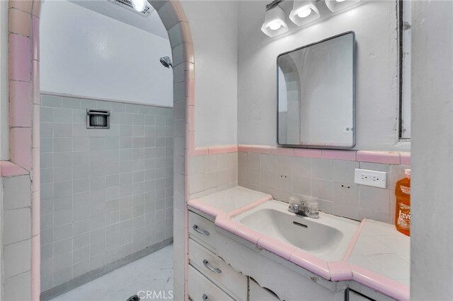 bathroom with tile walls and vanity