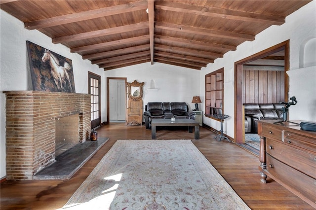 living room featuring vaulted ceiling with beams, a fireplace, wood ceiling, and wood finished floors