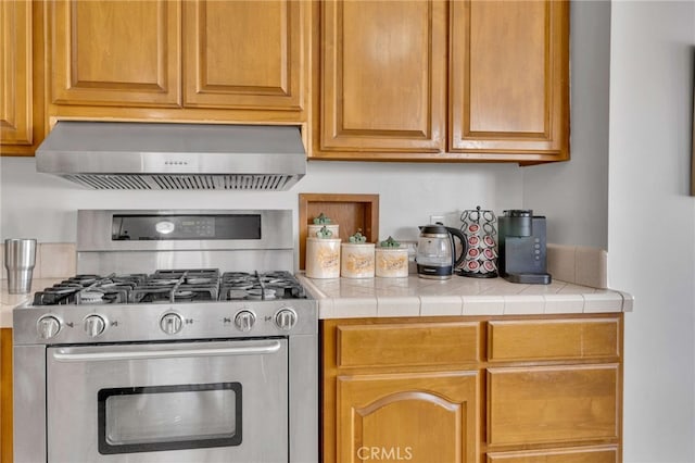 kitchen featuring stainless steel gas range oven and wall chimney exhaust hood