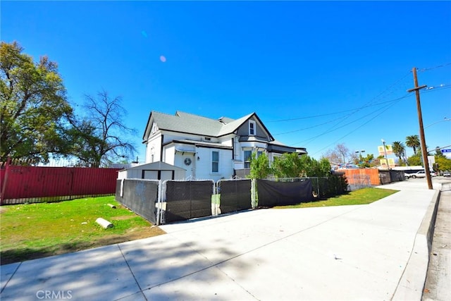 view of home's exterior with a lawn and fence