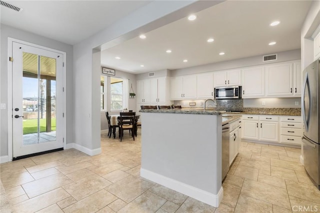 kitchen featuring visible vents, recessed lighting, dark stone countertops, appliances with stainless steel finishes, and white cabinetry