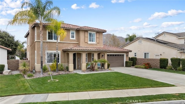 mediterranean / spanish home with a tile roof, a front yard, stucco siding, a garage, and driveway