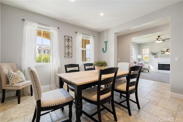 dining area featuring recessed lighting, baseboards, plenty of natural light, and a fireplace