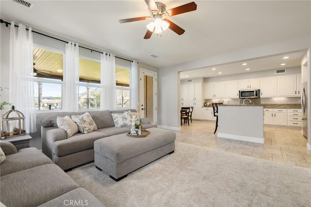 living room with recessed lighting, visible vents, baseboards, and ceiling fan