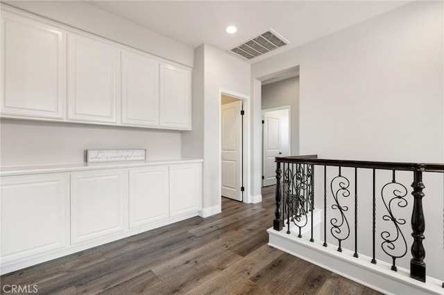 hall featuring recessed lighting, visible vents, and dark wood-style flooring