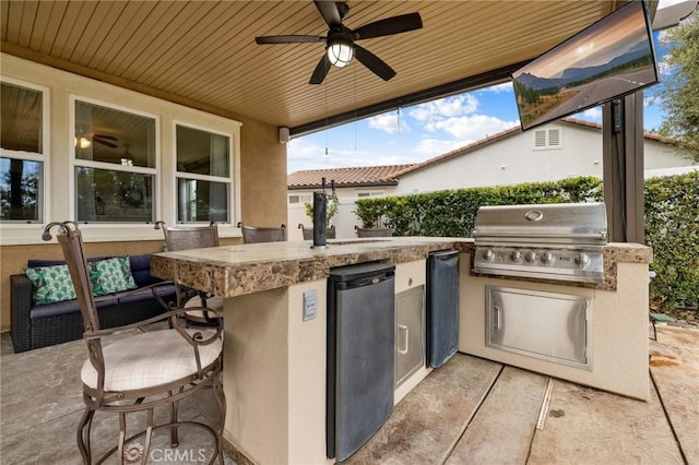 view of patio / terrace with visible vents, ceiling fan, outdoor wet bar, area for grilling, and an outdoor kitchen