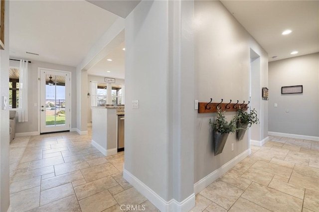 hallway with stone tile flooring, recessed lighting, and baseboards