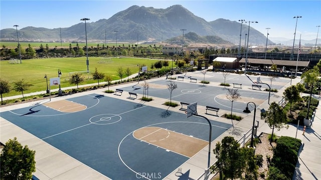 view of basketball court with community basketball court, a mountain view, and fence