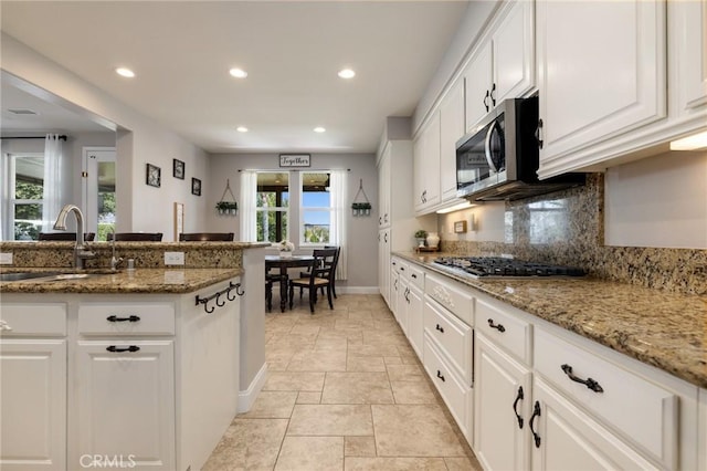 kitchen featuring a sink, white cabinets, tasteful backsplash, and stainless steel appliances