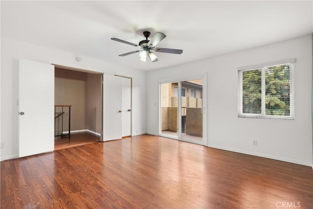 empty room featuring a ceiling fan, wood finished floors, and baseboards