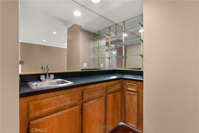 bar with recessed lighting, crown molding, a textured wall, and a sink