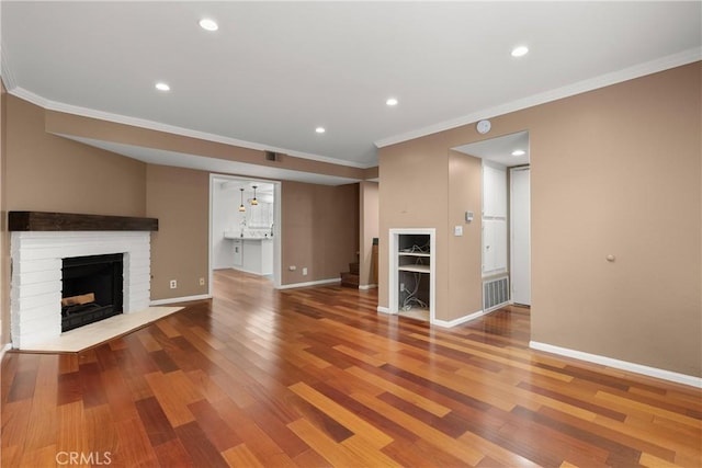 unfurnished living room featuring wood finished floors, stairway, a fireplace, and baseboards