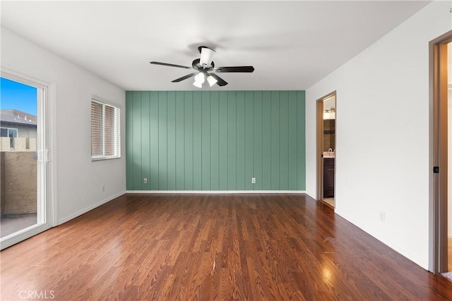 empty room featuring baseboards, a ceiling fan, and wood finished floors