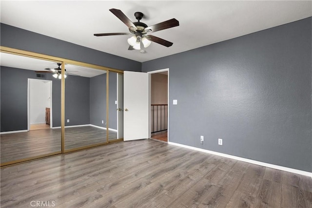 unfurnished bedroom with visible vents, baseboards, a closet, and wood finished floors