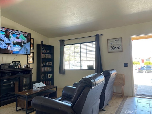 living area featuring light tile patterned flooring and a textured ceiling