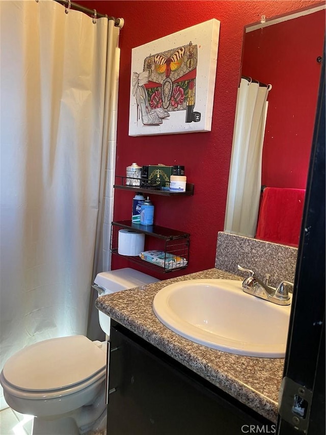 bathroom featuring vanity, curtained shower, and toilet