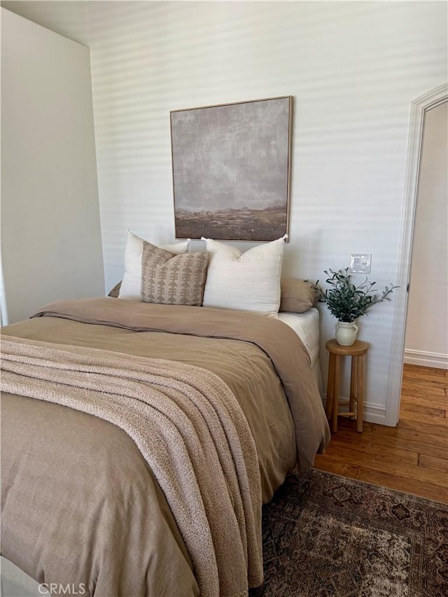 bedroom featuring wood finished floors and baseboards