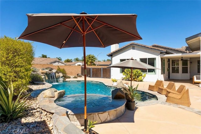 view of pool with a patio area, a fenced in pool, an in ground hot tub, and fence