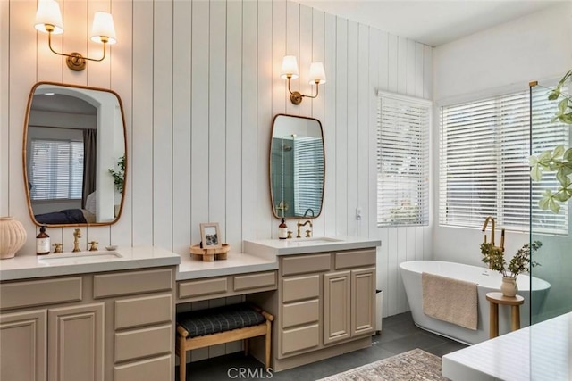 bathroom featuring tile patterned floors, ensuite bathroom, a soaking tub, and vanity